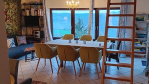 A dining area with a table, chairs, and a view of the outdoors.