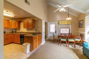Una cocina amplia con armarios de madera, lavavajillas integrado y un comedor con mesa y sillas.