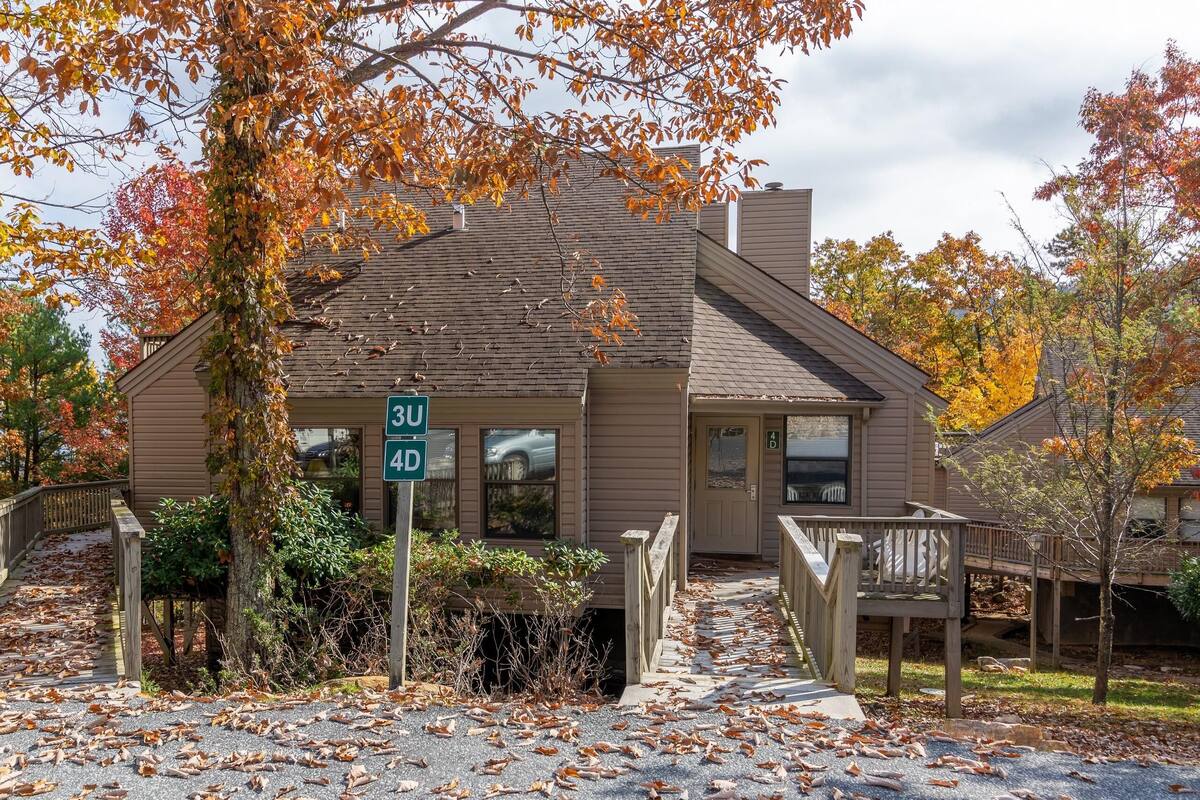 Une maison à deux étages avec un porche et une allée.