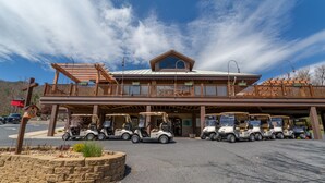A building with a covered parking area and multiple golf carts.