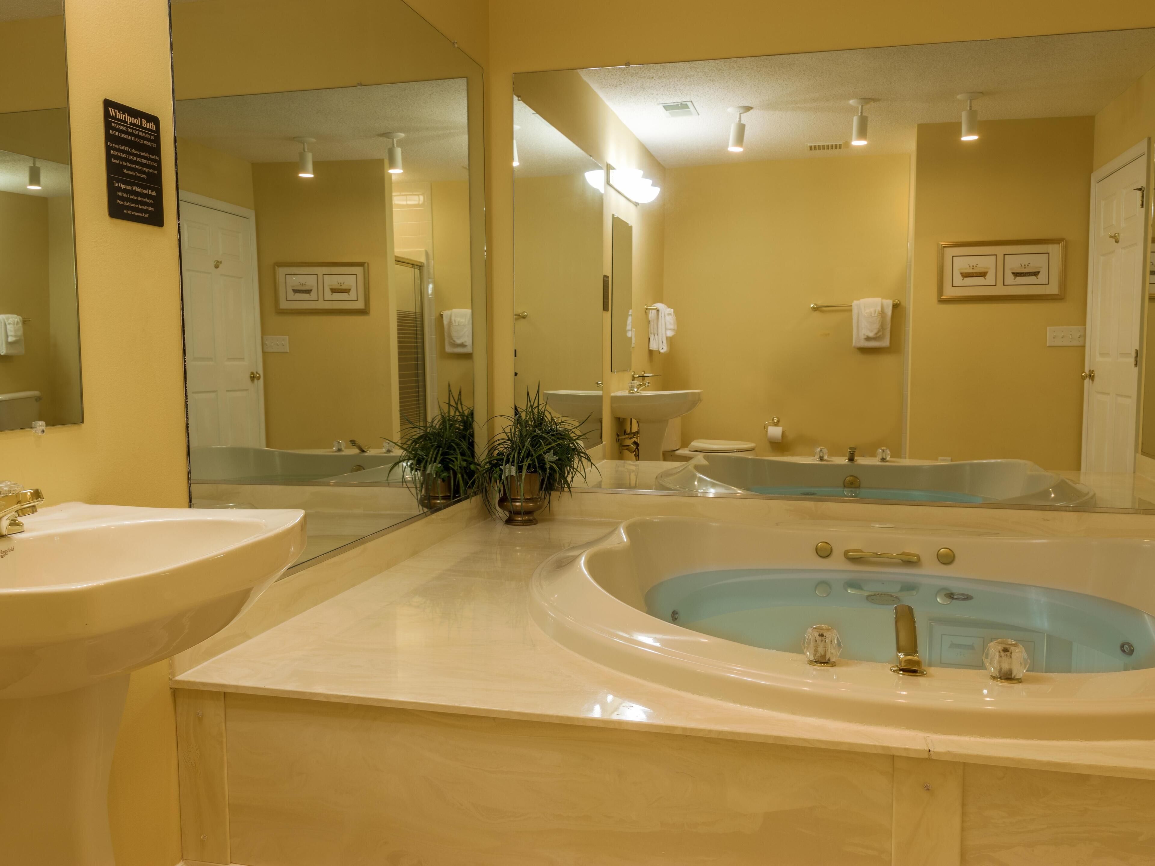 A bathroom with two sinks, a bathtub, and a large mirror.