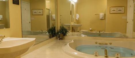 A bathroom with two sinks, a bathtub, and a large mirror.
