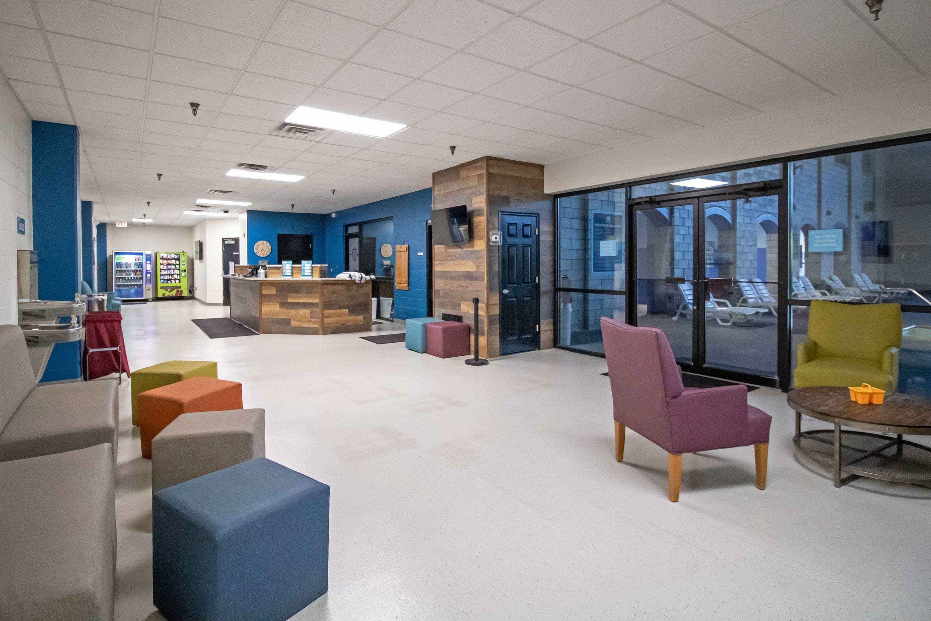 A spacious lobby with a reception desk, seating area, and a vending machine.