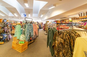 Tienda bien iluminada con diversos artículos de ropa a la vista, incluyendo sombreros, chaquetas y bolsos.