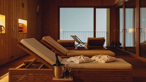 A wooden cabin with a balcony, lounge chairs, a minibar, and a view of the sky. - Campra Alpine Lodge & Spa (Blenio)