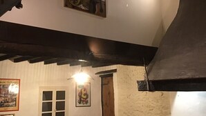 Ein rustikales Interieur mit freiliegenden Holzbalken, einem gerahmten Bild von Musikinstrumenten und einer Tür mit einem Poster.
