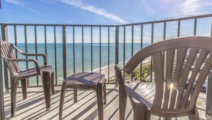 A balcony with chairs and a table overlooking the ocean. - Palace 1513 (Myrtle Beach)