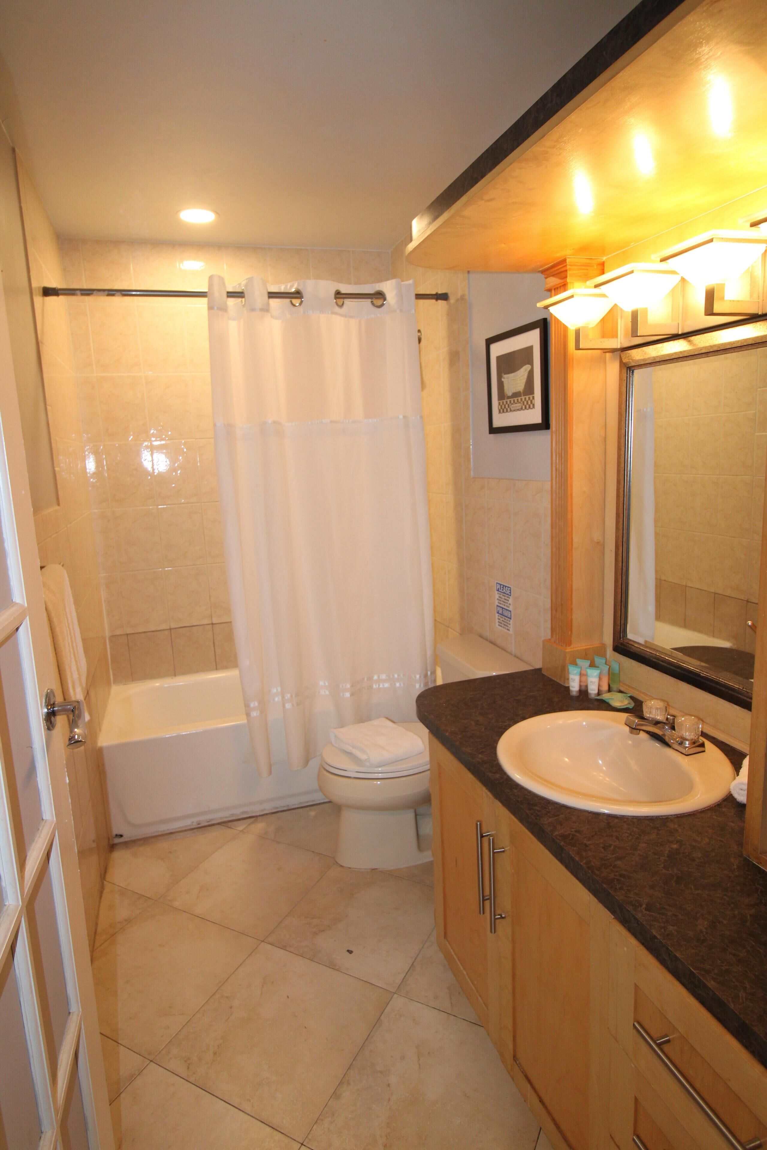 A bathroom with a bathtub, toilet, and sink.