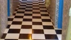 Un pasillo con suelo a cuadros y paredes estampadas.