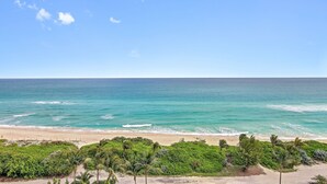 Una playa con aguas turquesas cristalinas, una orilla de arena y densa vegetación verde al frente.