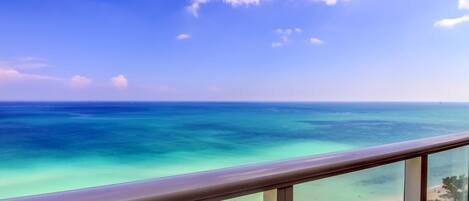 A balcony with a view of a beach and ocean.