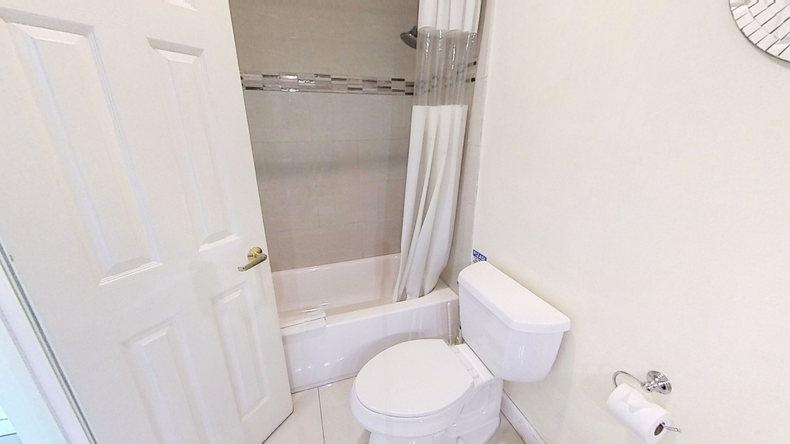 A bathroom with a toilet, a bathtub, and a shower curtain.
