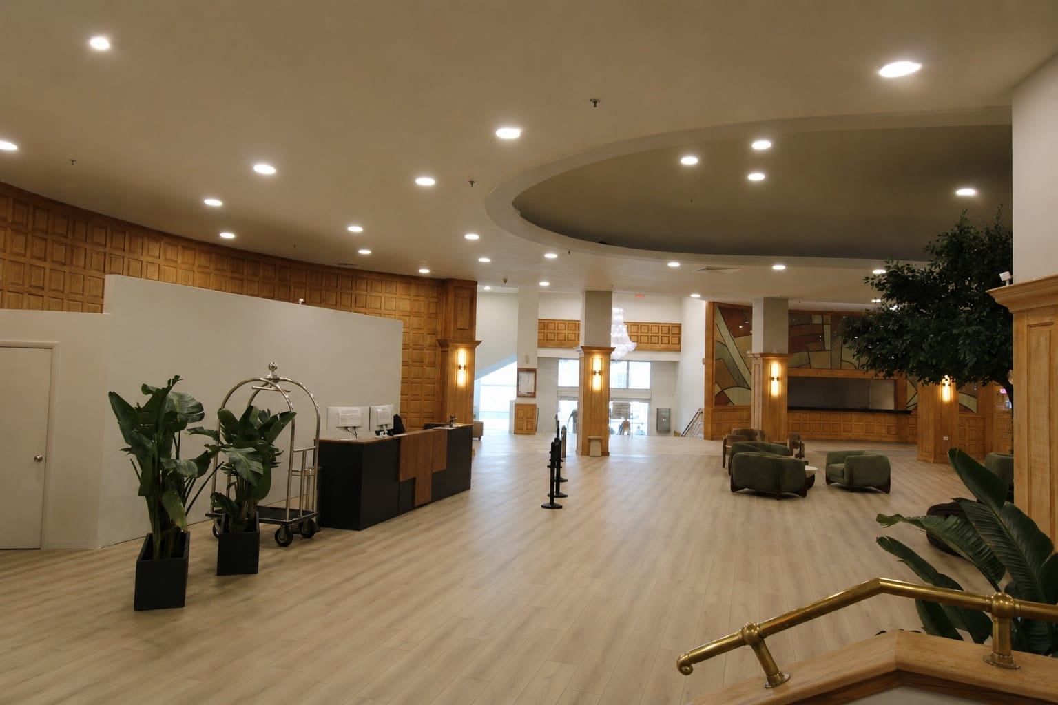 Un vestíbulo amplio con una recepción, zona de estar y una escalera que conduce a los pisos superiores.
