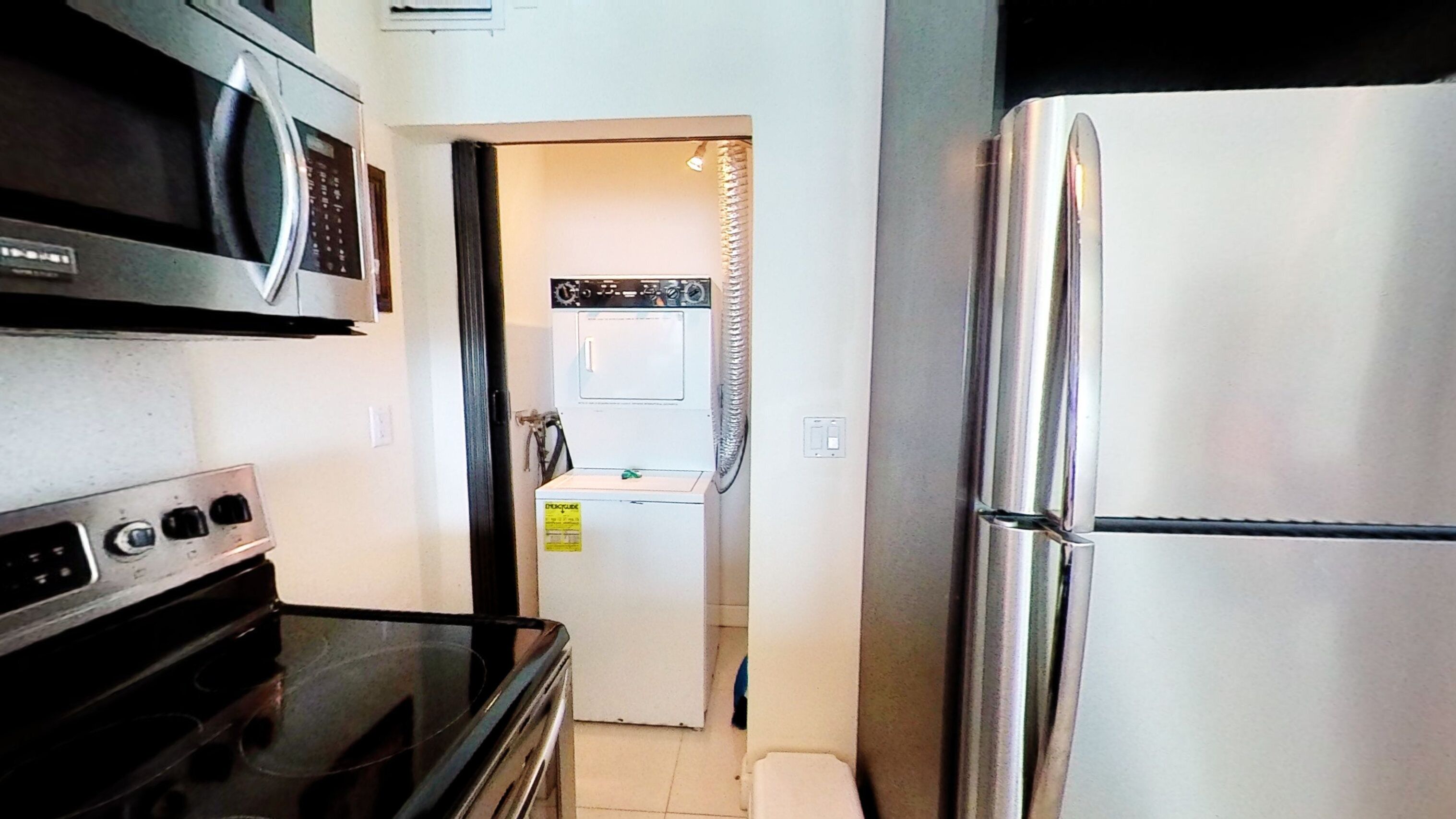 A kitchen with a microwave, stove, and refrigerator.