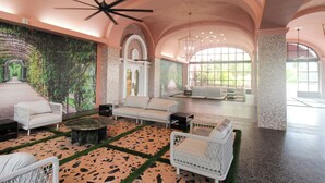 A spacious lobby with a high ceiling, a large mural, and a seating area with white furniture. - Alexander 1211 with Beach Access, 2 pools, sauna (Miami Beach)