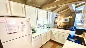 A kitchen with white cabinets, a refrigerator, a sink, and a stove. There is a note on the refrigerator about smoking being prohibited. - Mountain Retreat.                  (Mammoth Lakes)