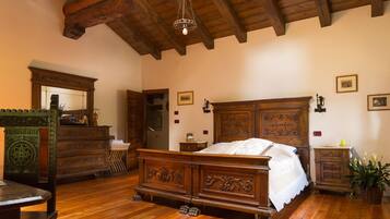 Um quarto tradicional de madeira com uma cama grande, cômoda e espelho.