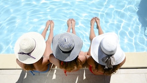 Two people sitting by a pool with their feet in the water. - Lake Arrowhead Resort and Spa (Lake Arrowhead)