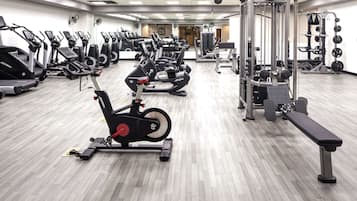 Uma academia com vários equipamentos de exercício, incluindo esteiras e equipamentos de musculação.