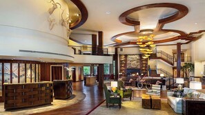 A spacious lobby with a high ceiling, a fireplace, and a staircase. - Lake Arrowhead Resort and Spa (Lake Arrowhead)