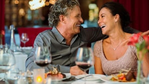 A couple dining at a restaurant with a red tablecloth and candles. - Lake Arrowhead Resort and Spa (Lake Arrowhead)