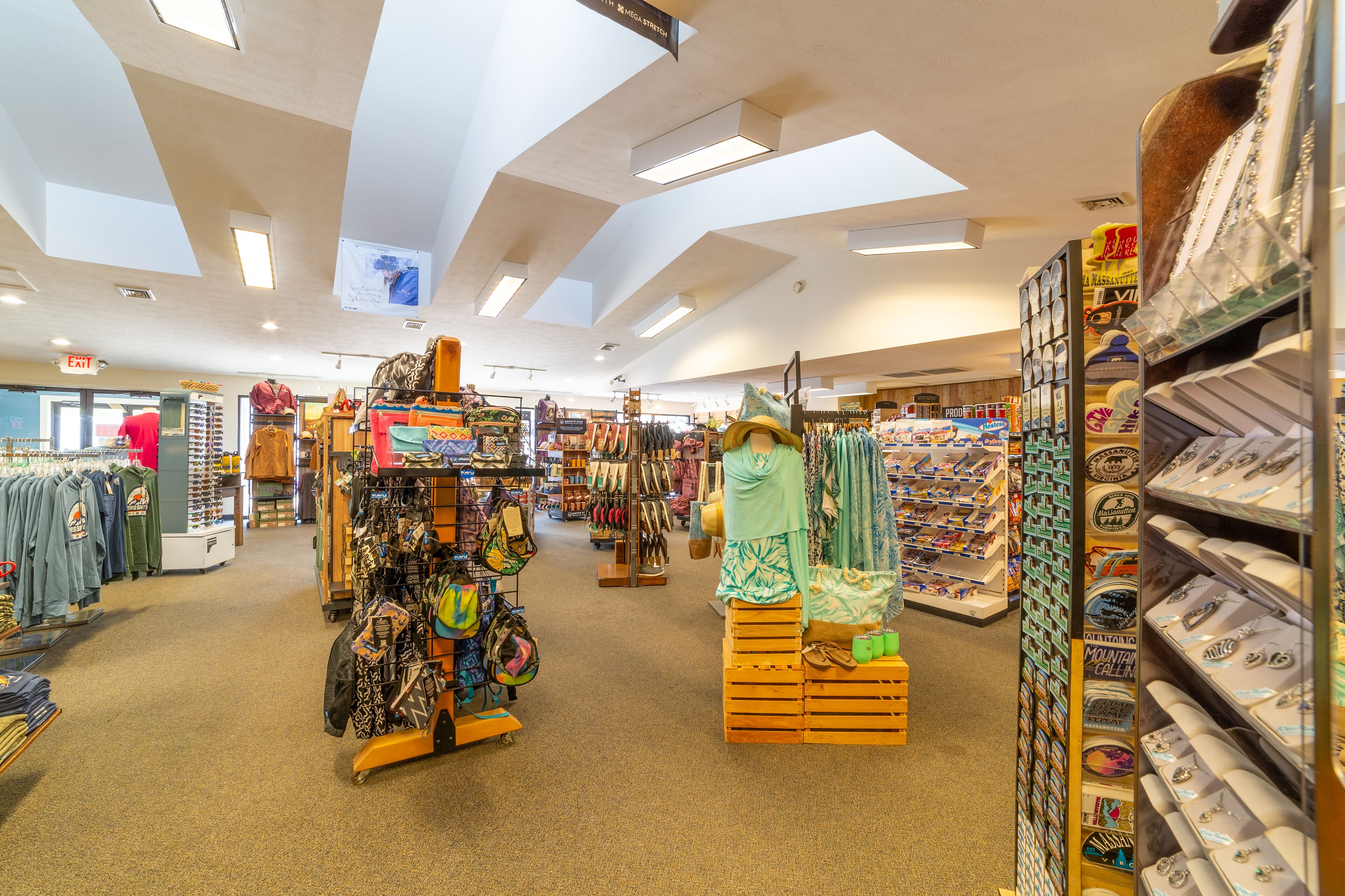 A spacious retail store with wide aisles, various clothing and accessories on display, and a high ceiling with skylights.
