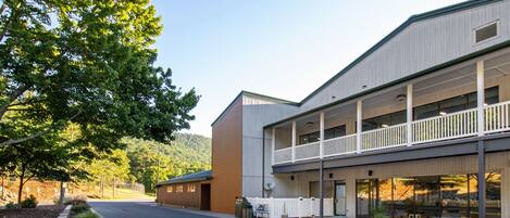 A building with a covered walkway and a landscaped area with trees.