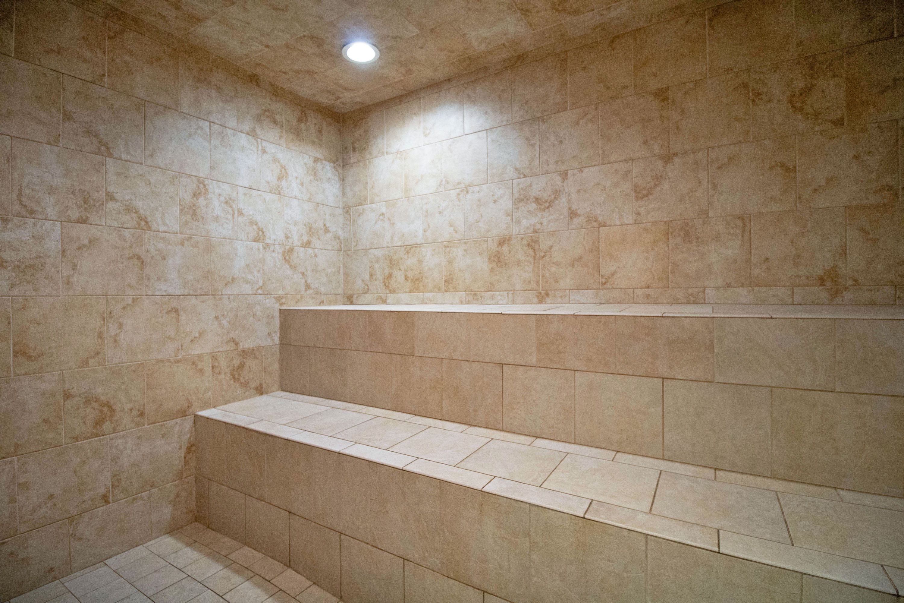 Un espacio de ducha con azulejos y un banco integrado.