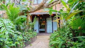 A pathway leading to a building surrounded by lush greenery and a wooden fence. - Mayan Monkey Isla Mujeres | Social Hotel (Isla Mujeres)