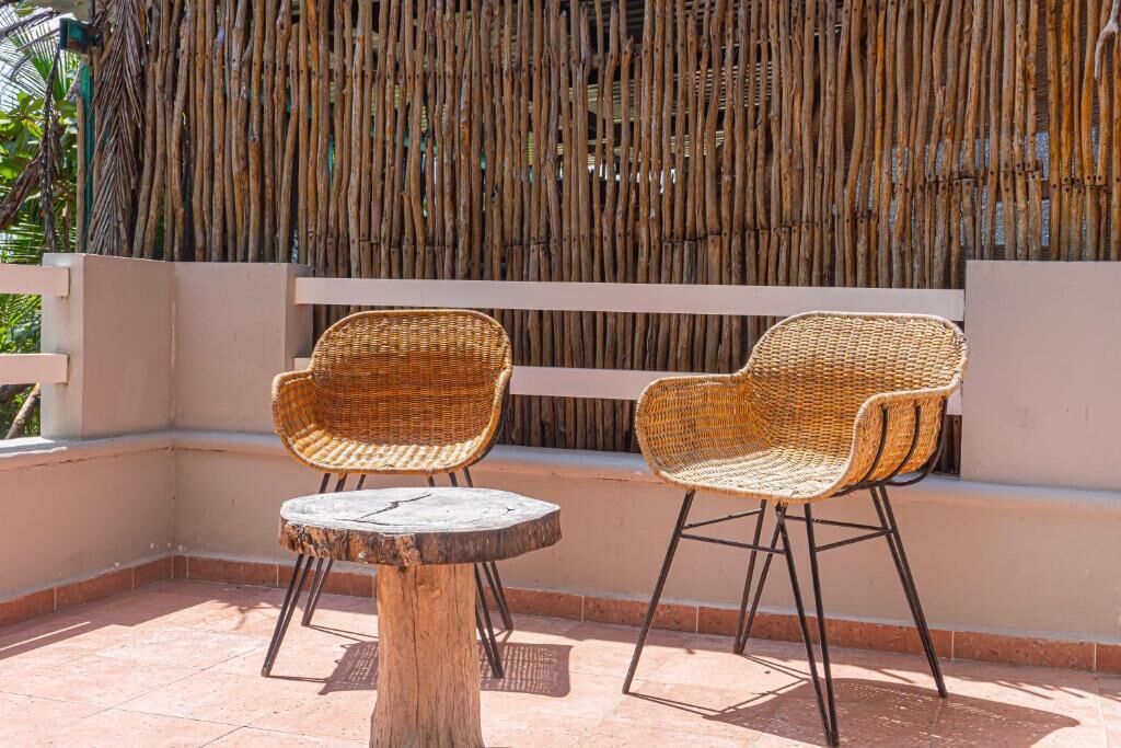 A balcony with wicker chairs and a small round table.