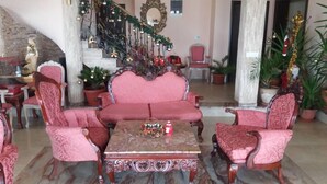 A spacious lobby with a grand staircase, a red sofa set, and a decorative table. - Akva Gold Apartmani (Arandelovac)