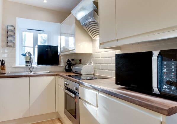 Enjoy cooking in this well-lit kitchen with a stainless steel range and microwave.