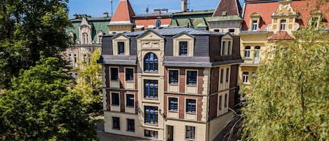 A multi-story building with a central entrance, large windows, and a brick facade.
