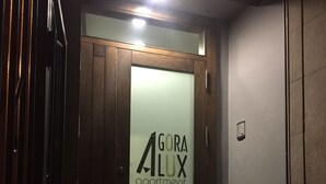 An entrance to a building with a glass door displaying "GORA ALUX apartment" sign. - ÁgoraLux, The door of Ourense. (Ourense)