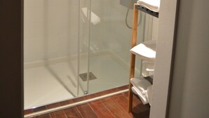 A glass-enclosed shower stall with a white sink and a wooden shelf. - ÁgoraLux, The door of Ourense. (Ourense)