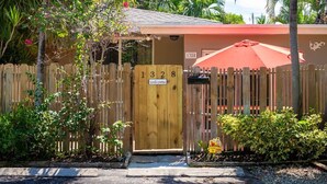 A wooden gate with a welcome sign, a red umbrella, and a house number 1328. - 1BR with Private, Fenced Deck (Fort Lauderdale)