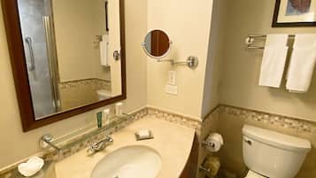 A bathroom with a sink, mirror, toilet, and towel rack.