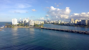 A coastal cityscape with high-rise buildings, a bridge, and a clear sky.