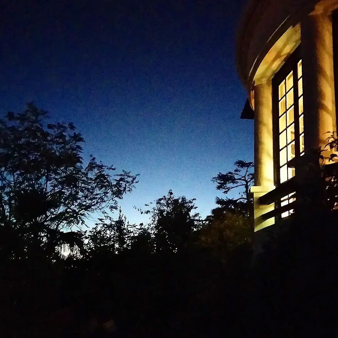 Un edificio de estilo arquitectónico clásico, con una columna destacada y un ventanal grande.