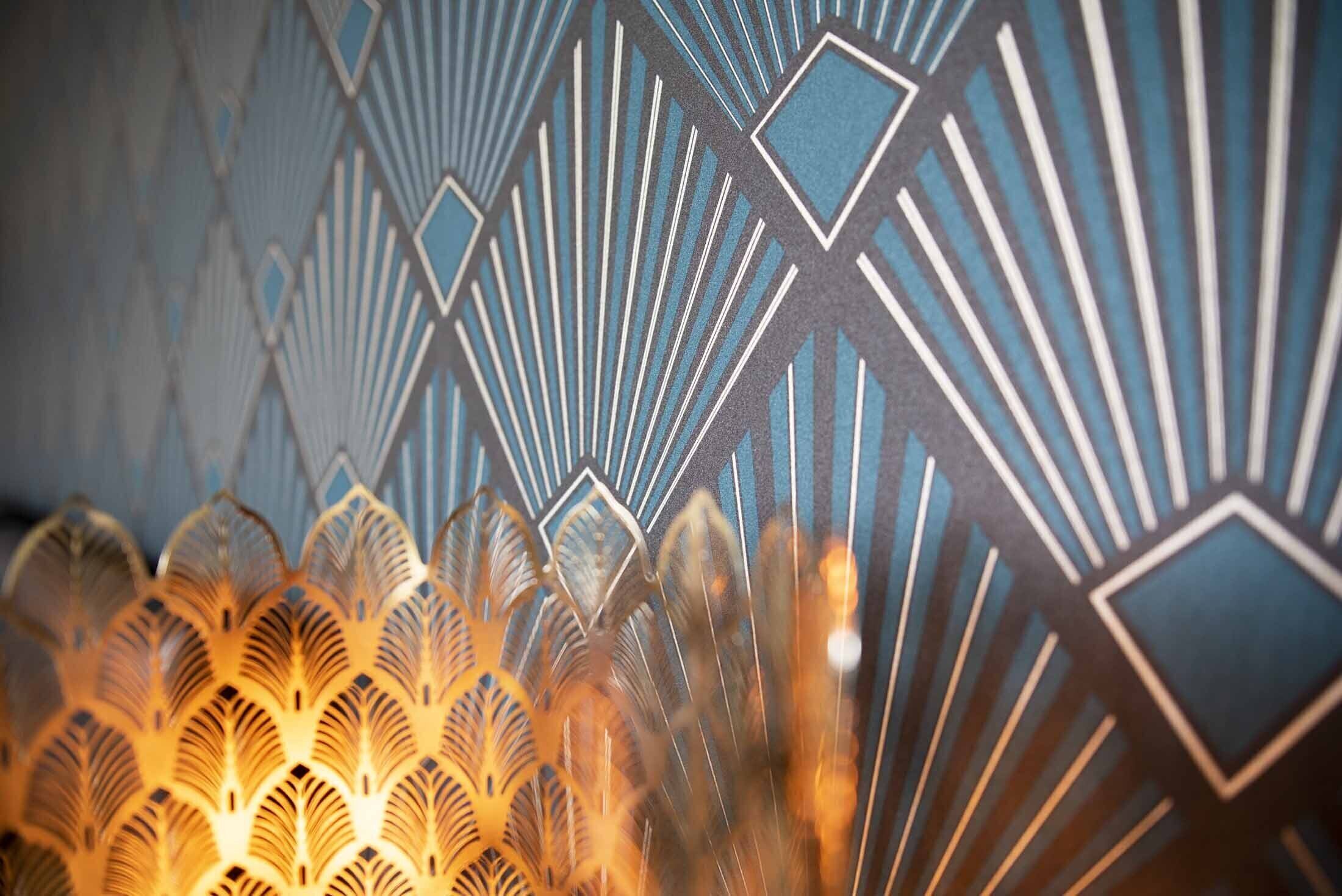 A close-up of a patterned wall with geometric shapes and a decorative light fixture.