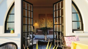 An open doorway leading to a cozy interior with a sofa, a coffee table, and a potted plant.