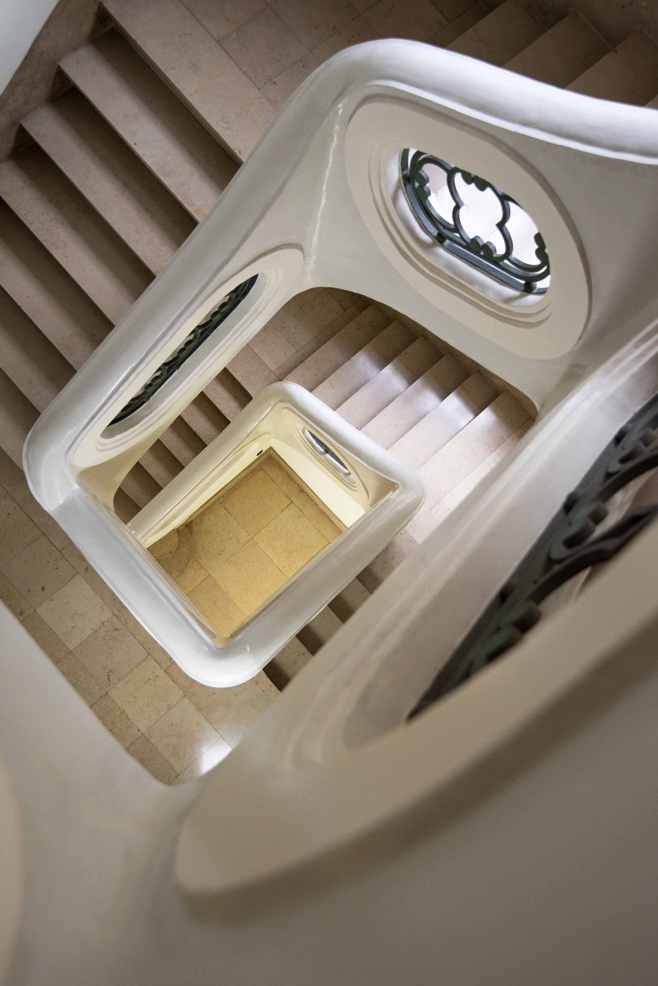 Een witte, moderne stoel met een uniek ontwerp, inclusief een ronde uitsparing en een klein vakje.