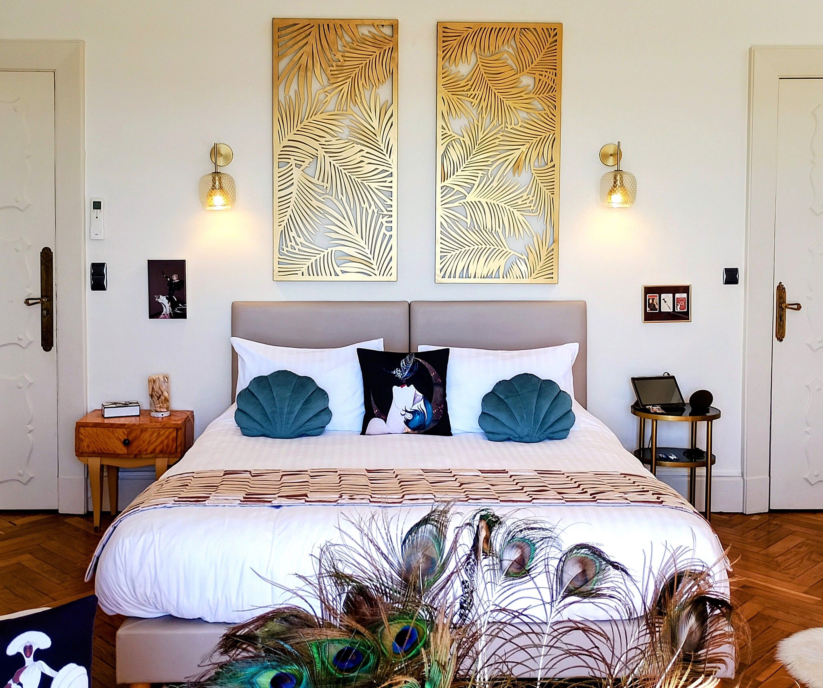 A bedroom with a bed, two wall-mounted light fixtures, a bedside table, and a nightstand.