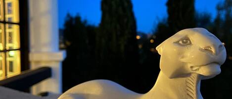 Una escultura de piedra blanca de un león en un jardín.
