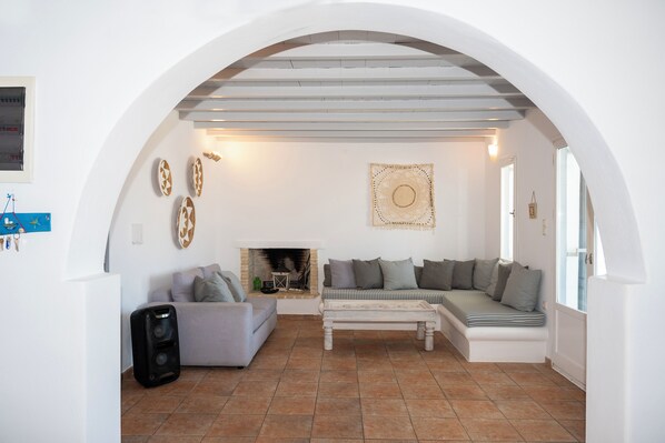 Una sala de estar con chimenea, sofá, mesa de centro y televisor.