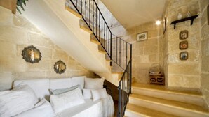 A staircase with a black railing leading to a landing. - Discover Tranquility: rustic elegance in this beautifully converted farmhouse. (San Lawrenz)