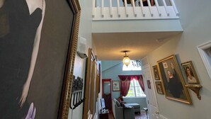 A spacious hallway with a high ceiling, a chandelier, and a staircase leading to an upper level. - Disney Themed Home! Magic Kingdom Inspired!!  Hidden Mickeys!!! (Davenport)