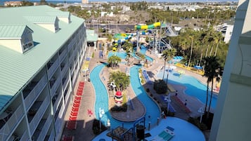 A resort with a large pool area, multiple water slides, and a view of the ocean.