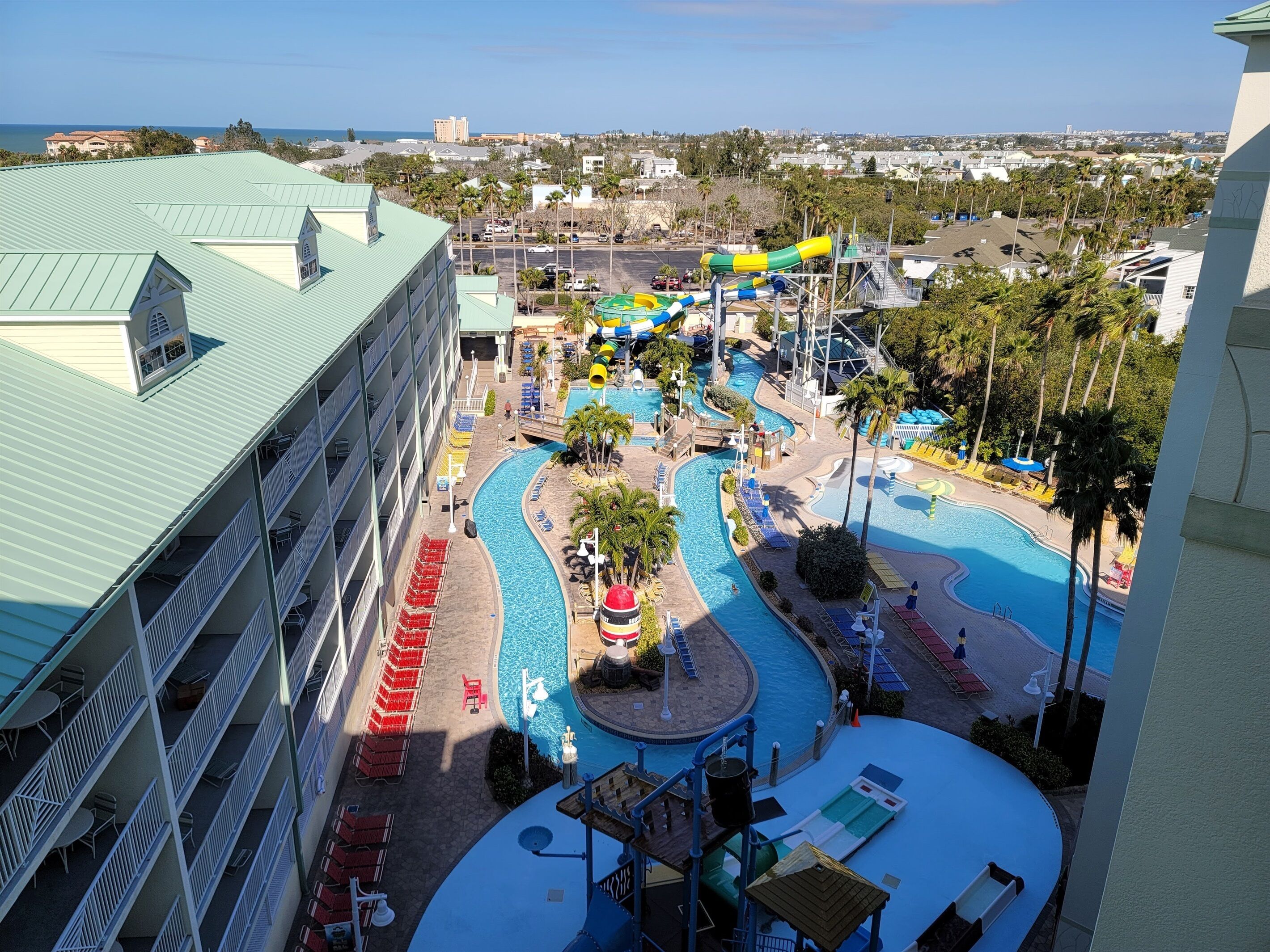 A resort with a pool area, water slides, and a view of the ocean.