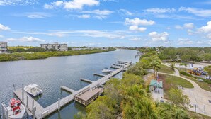A river with a dock, a boat, and a small pavilion with an American flag. - Waterfront, Harbourside, Water Park, Beach, #5515 (Indian Rocks Beach)